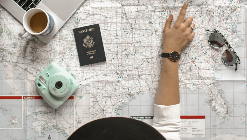 femme qui pointe une destination sur une carte du monde femme qui pointe une destination sur une carte du monde