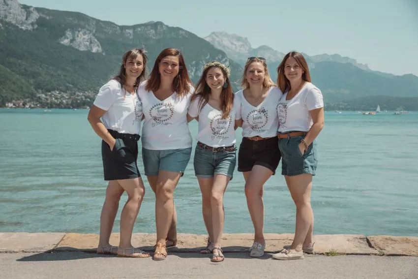 EVJF à Chambéry : un shooting photo entre amies face aux montagnes Groupe d’amies posant lors d’un shooting EVJF à Chambéry avec vue sur les montagnes et le lac