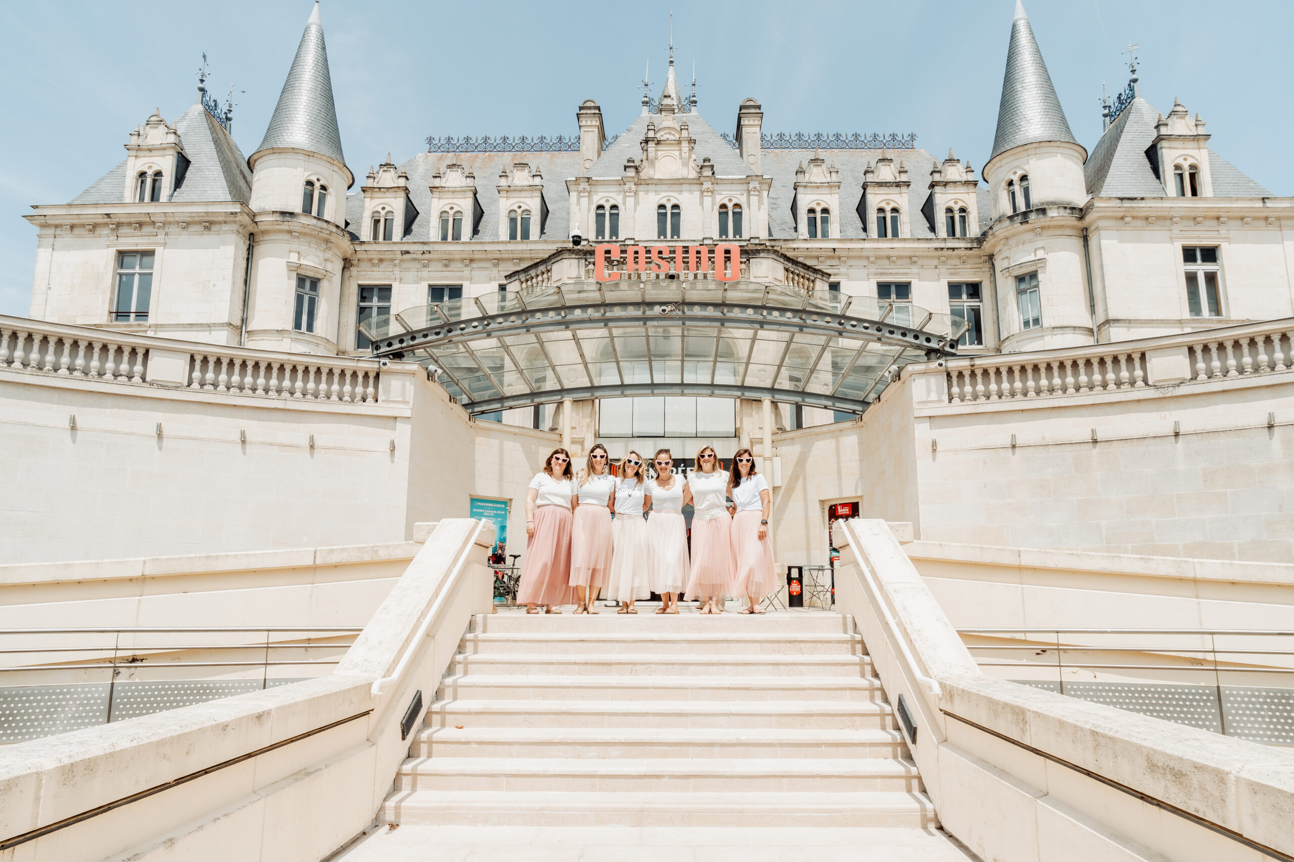 Photo de groupe EVJF devant le Casino d'Arcachon, toutes en jupes rose poudré.