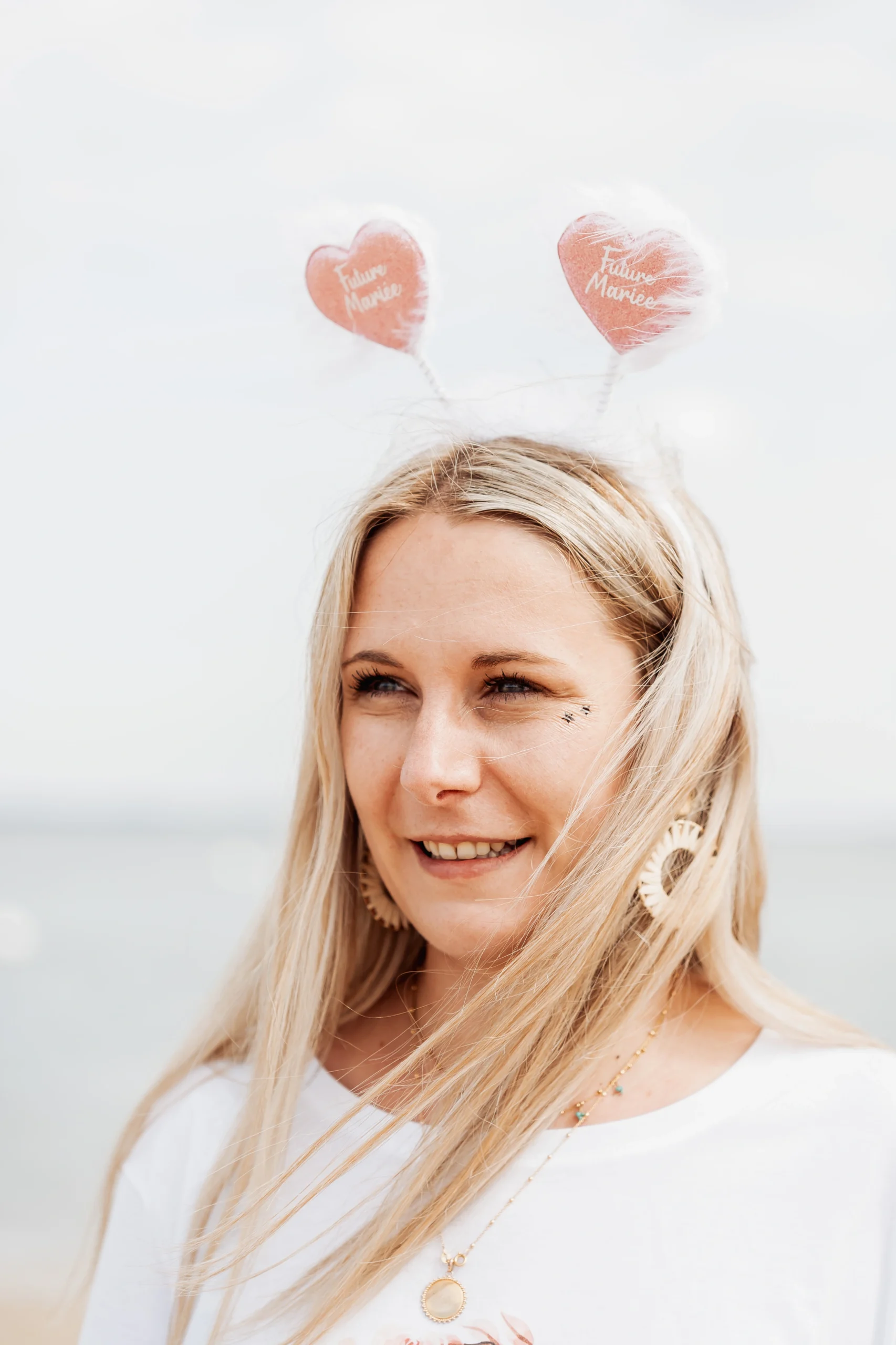 Future mariée en gros plan avec serre-tête "Future Mariée" sur la plage à Arcachon lors de son EVJF.