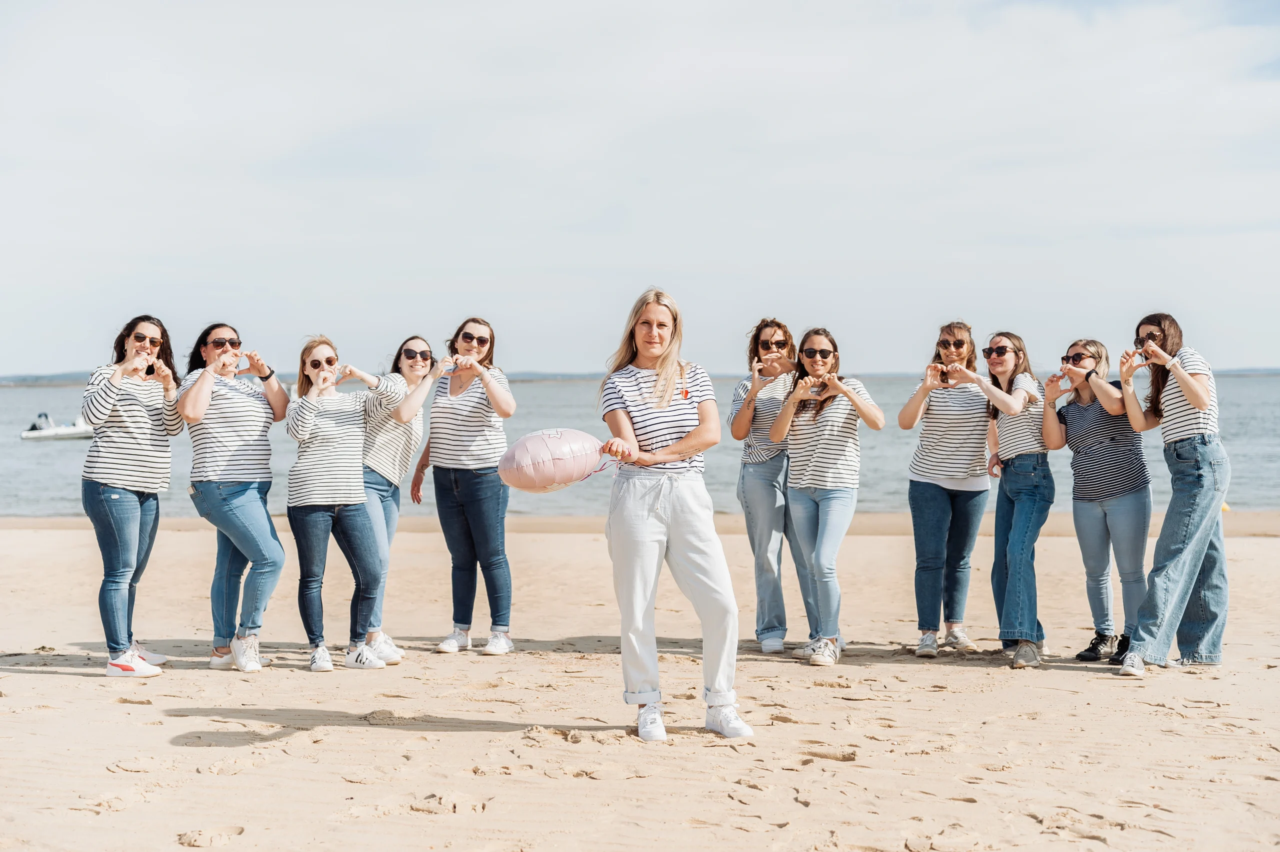 Groupe de filles en marinières autour de la future mariée sur la plage d’Arcachon pour un enterrement de vie de jeune fille.