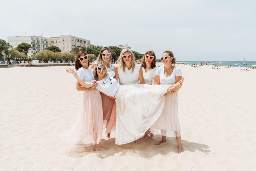 mies portant la future mariée dans une ambiance festive sur le sable d’Arcachon.