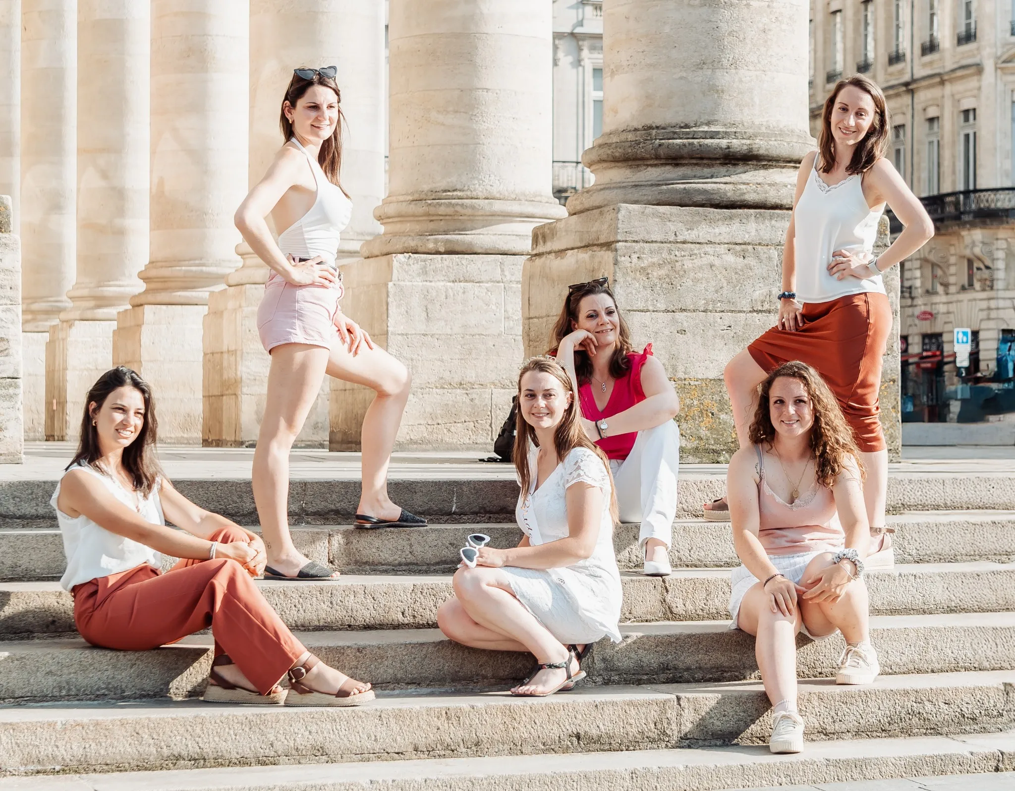 Enterrement de vie de jeune fille à Bordeaux devant les colonnes du Grand Théâtre, en tenues estivales élégantes.