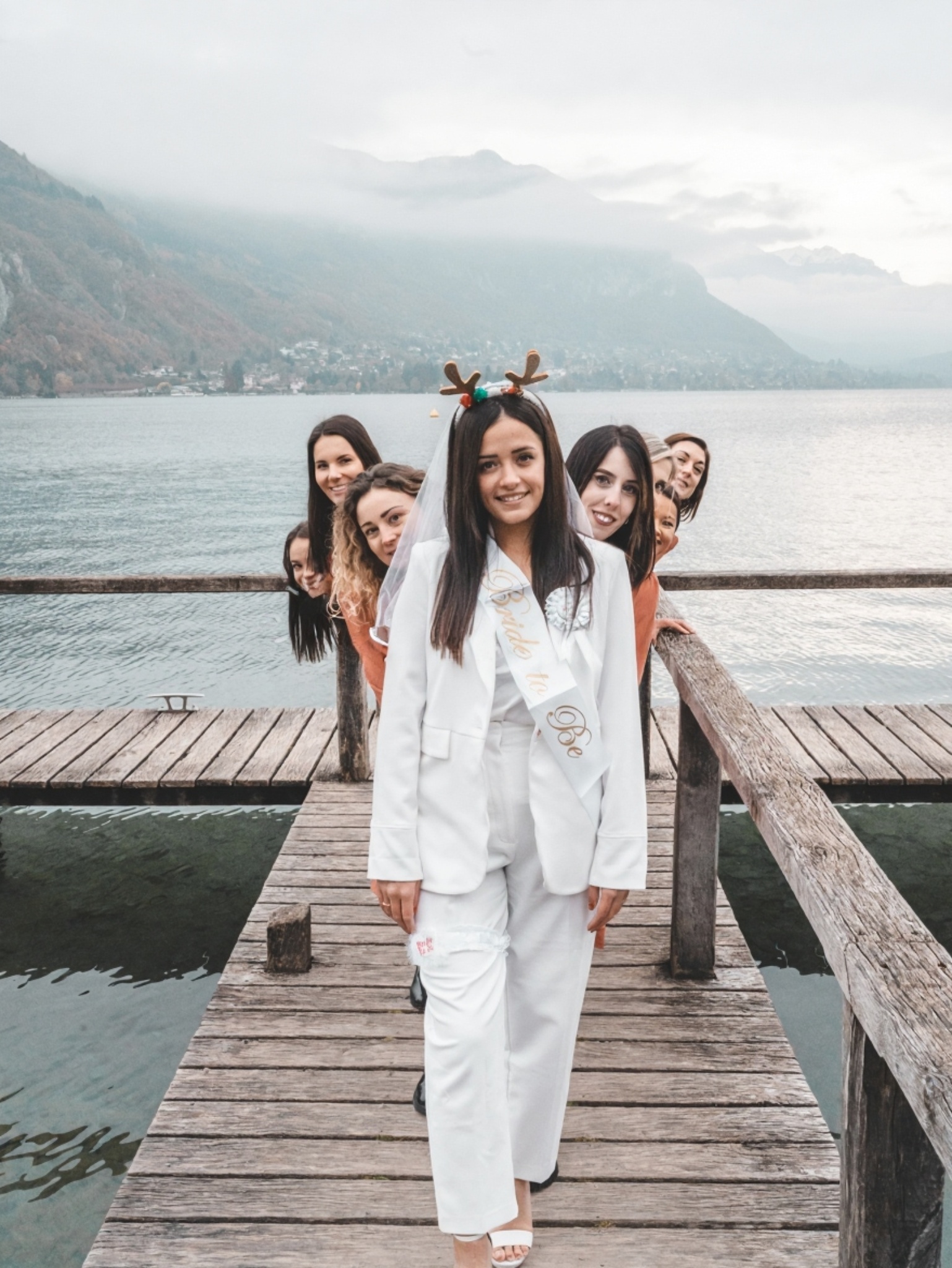 evjf-chambery-groupe-alignement-ponton Photo fun de la mariée avec ses amies en ligne derrière elle sur le ponton du lac d’Annecy