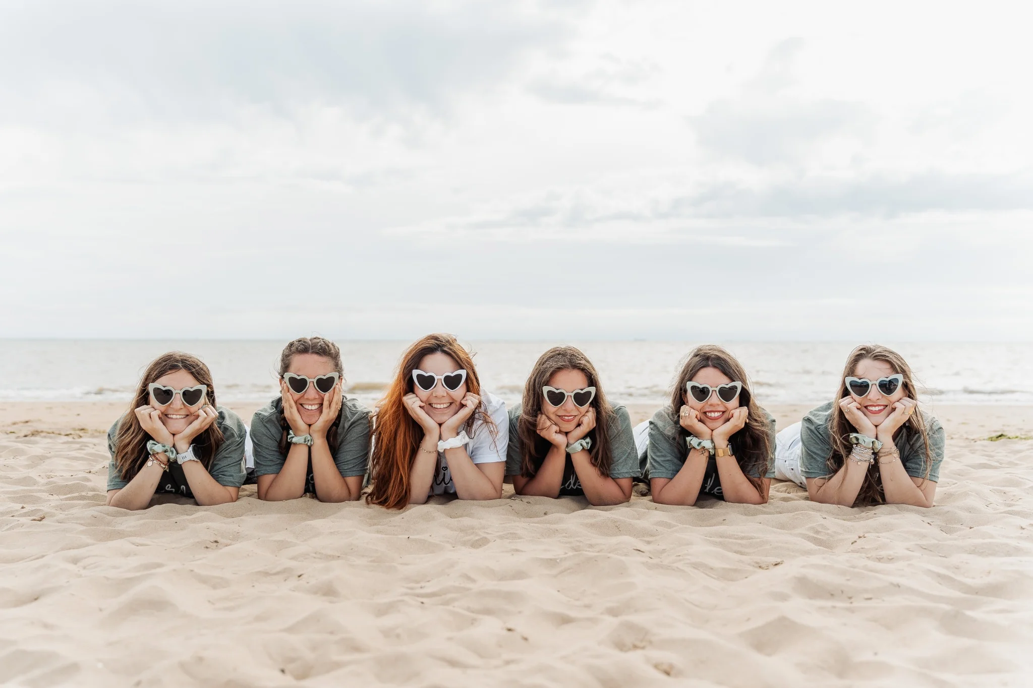 Filles allongées dans le sable avec lunettes en forme de cœur à La Rochelle