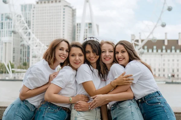 Groupe de filles en t-shirts blancs lors d'un EVJF à Londres devant le London Eye