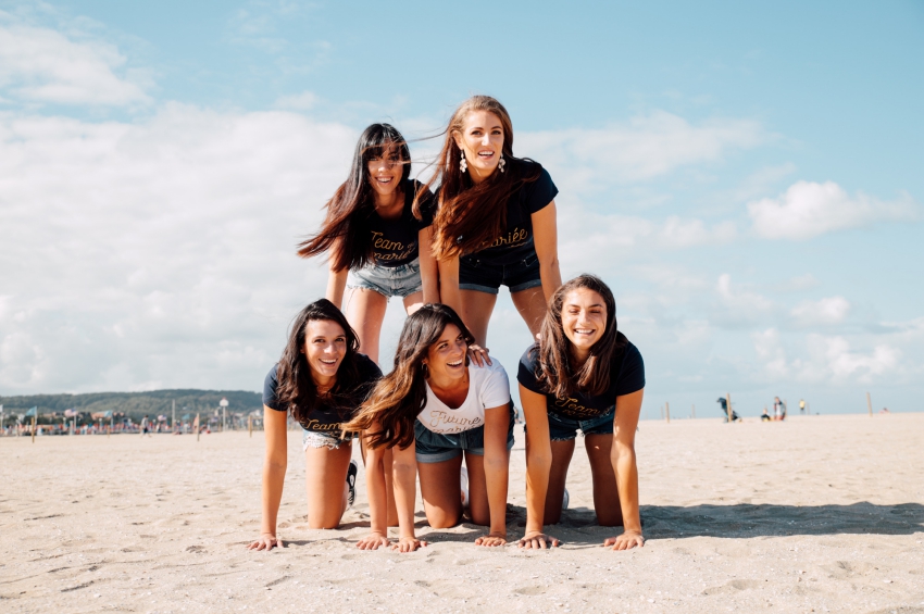 groupe de femmes qui samuse en faisant une pyramide humaine sur la plage