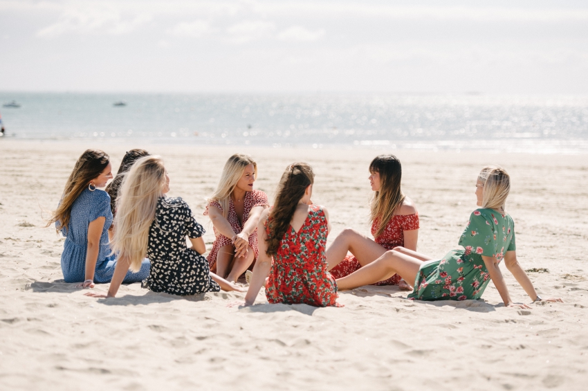 groupe de filles sur la plage formant un cercle et discutant