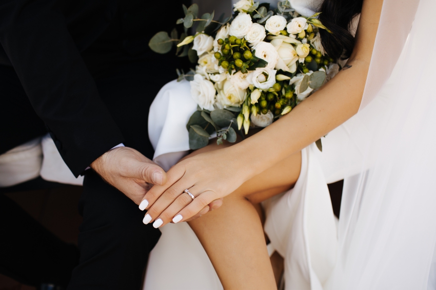 mains de jeunes maries avec bagues de fiancailles et bouquet de la mariee